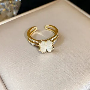 Vista dettagliata di un anello placcato oro 14k con zirconi e motivo a quadrifoglio bianco