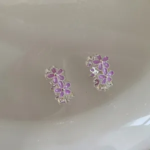 Vista detallada de elegantes pendientes de aro con flores de esmalte morado