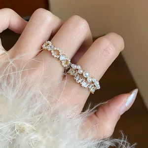 Dettaglio di anelli placcati oro 14 carati con eleganti perle e zirconi brillanti