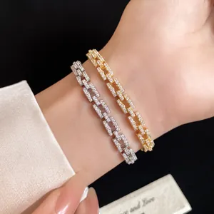 Close-up of elegant gold and silver plated zirconia linked bracelets on model wrist