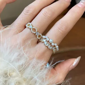 Primo piano di un elegante anello placcato in oro con perle delicate e zirconi