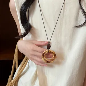 Detailed shot of a vintage resin double circle pendant necklace on long dark cord