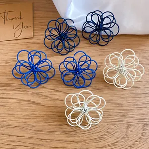 Detailed macro view of elegant wire-wrapped flower stud earrings in navy, blue and white colors