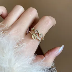 Dettaglio di un set di anelli placcati in oro 14k con zirconi e design logo H