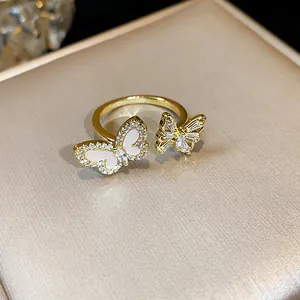 Primo piano di un elegante anello dorato con due motivi a farfalla scintillanti