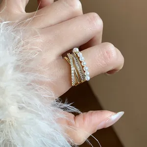 Primo piano di anello multistrato placcato oro 14k con zirconi brillanti e perle