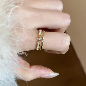 Dettaglio di eleganti anelli placcati oro 14k con inserto in conchiglia e zirconi
