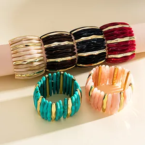 Detail view of marbled acrylic geometric elastic bracelets with gold-tone accents