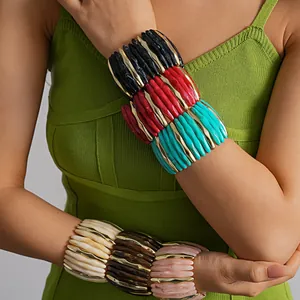 Close-up of chunky acrylic marbled geometric elastic statement bracelets stacked on model's arms