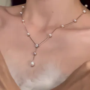 Elegant French style pearl necklace with delicate flower pendant worn by a model