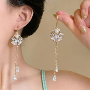 Elegant gold shell earrings with pearl detail and sparkling crystal tassel drops for women