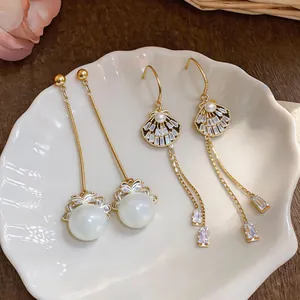 Close-up detail of elegant gold-tone tassel earrings with lustrous pearls and cubic zirconia