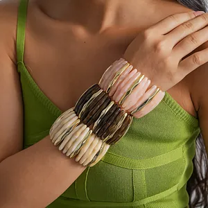 Close-up of marbled acrylic bracelets with gold-toned geometric accents for women