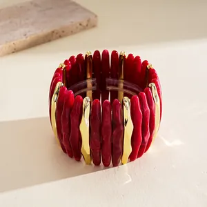 Detailed view of fashionable red marbled acrylic and gold-tone geometric stretch bracelet