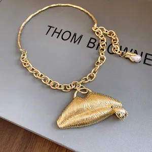 Detailed view of a luxury gold textured lips pendant necklace adorned with crystals and a pearl