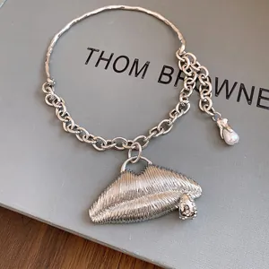 Close-up detail of silver textured metal lip pendant with sparkling rhinestone accents