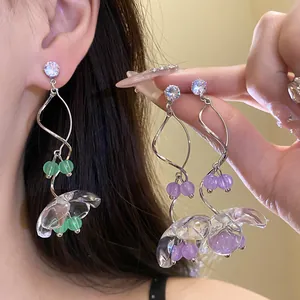 Détail de boucles d'oreilles muguet en résine transparente avec perles colorées
