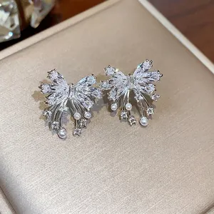 Elegant silver-toned butterfly bow earrings with sparkling zircons and fine pearls.
