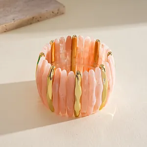 Macro view of marbled acrylic and gold-tone metal segments on a stretch bracelet