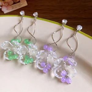 Boucles d'oreilles muguet élégantes avec fleurs en résine et cristaux étincelants.