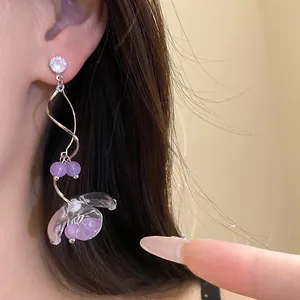 Gros plan de boucles d'oreilles élégantes en résine fleur de muguet portées à l'oreille