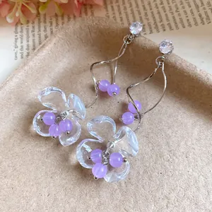 Vue détaillée des boucles d'oreilles fleurs en résine et des pendants avec perles lavande