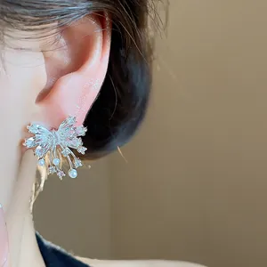 Detailed view of elegant silver bowknot earrings with sparkling zirconia and pearls