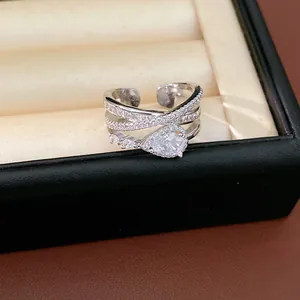 Macro detail of elegant silver criss-cross ring set with shimmering pear-shaped zirconia stones