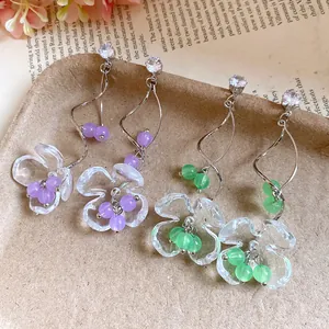 Détail de boucles d'oreilles élégantes en résine transparente avec perles de verre