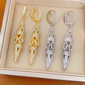 Detailed view of elegant gold and silver hollow rhombus earrings with pavé stones.