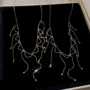 Close-up of delicate gold tassel necklace with shimmering crystal accents in a box.
