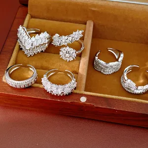 Detailed close-up of various silver rings with marquise zircons inside a wooden box