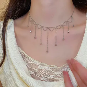 Detailed view of a silver tassel beaded necklace with delicate drop pendants.