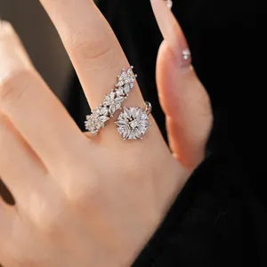 Close-up of elegant V-shaped flower ring with sparkling marquise zircons on a hand.