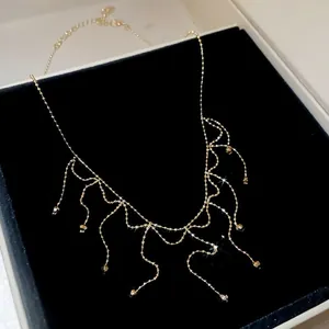 Detailed view of a gold-toned fringe necklace with elegant bead accents.
