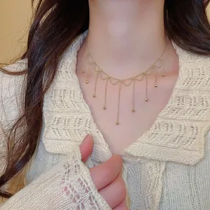 Detailed close-up showing an elegant gold tassel choker necklace on a female model