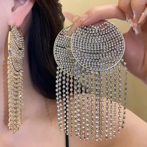 Macro view of luxurious silver round earrings with long rhinestone tassels