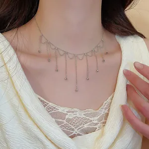 Detailed close-up showing an elegant silver fringe tassel necklace on a model's neck