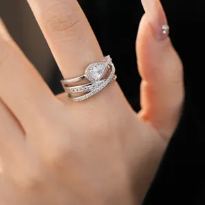 Close-up detail of a vintage palace style silver ring featuring a pear-cut zircon on a hand