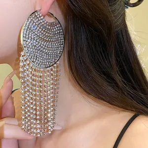 Close-up of sparkling rhinestone hoop earrings with long tassels on model