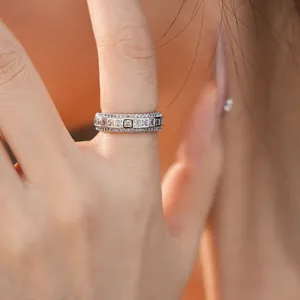 Close-up of an eternity band ring with square and round zircons on a model's finger