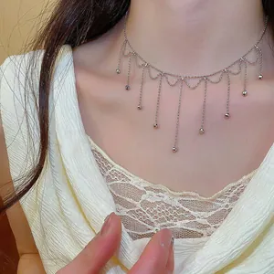 Detailed view of elegant silver tassel choker necklace on a female model's neck.