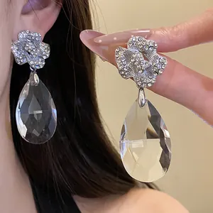 Détail de boucles d'oreilles pendantes en fleur et goutte de cristal avec tige en argent