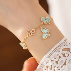 Detailansicht eines eleganten Goldarmbands mit Schmetterlingsanhängern und Zirkoniasteinen.