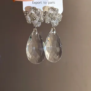 Vue rapprochée de boucles d'oreilles fleur en cristal avec gouttes de verre facettées.