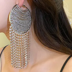 Detailed macro view of silver needle round hoop earrings featuring long rhinestone tassels
