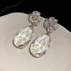 Gros plan de boucles d'oreilles fleur avec de grandes gouttes en cristal facetté
