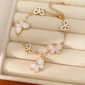 Detailansicht eines goldfarbenen Armbands mit Zirkonia- und Muschel-Schmetterlingen.