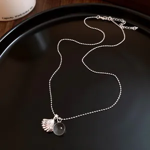 Dettaglio di una collana con ciondolo a conchiglia argento e sfera di resina trasparente