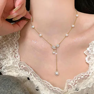Détail d'un collier lasso élégant en perles et feuilles de zircon plaqué or 18 carats